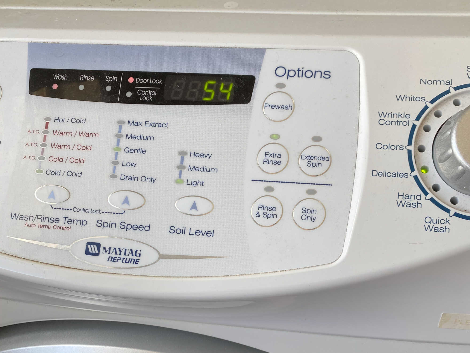 A washing machine showing the ideal settings for washing a secondhand wedding dress cold water on gentle delicates cycle.